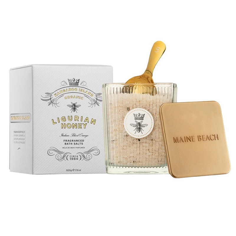 Ligurian Honey scented bath crystal salts with packaging and golden scoop on a white background