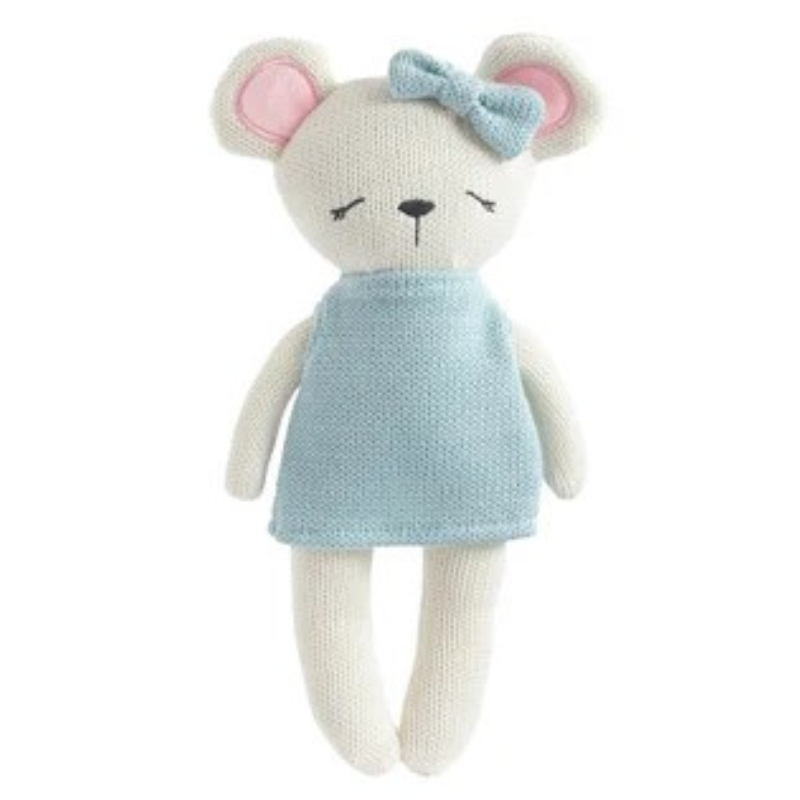 A knitted teddy bear toy with a cream-colored body, pink inner ears, a light blue bow, and a light blue dress, shown against a plain white background.