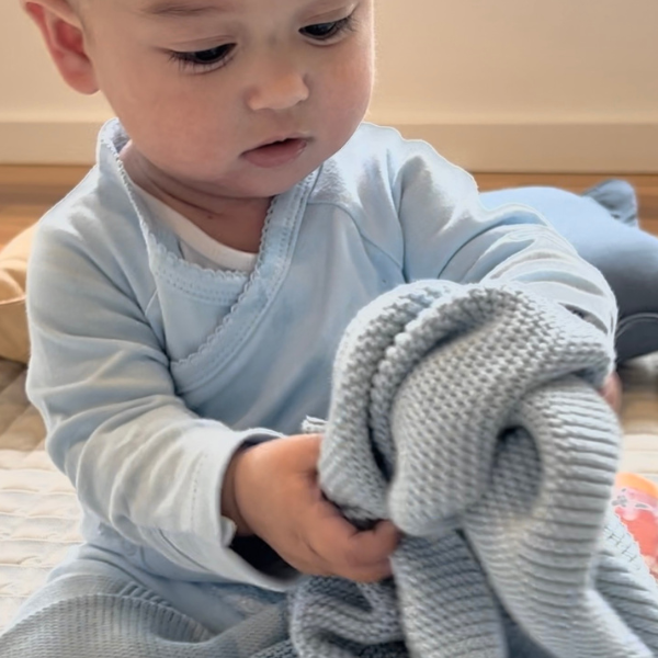 baby sitting with personalised knitted baby blanket blue