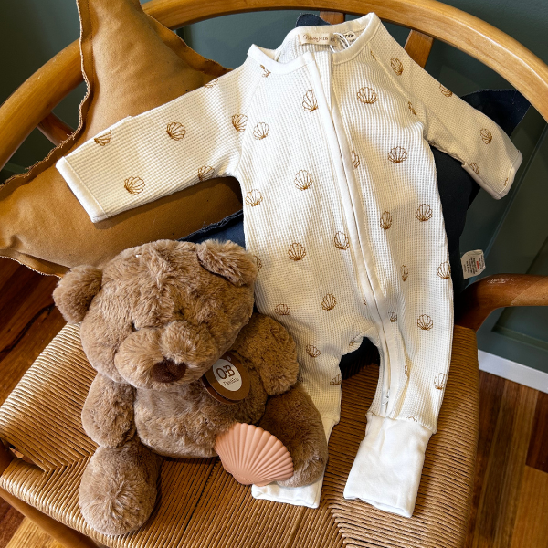 Ocean dreaming baby gift hamper contents teddy bear baby romper and shell teether sitting on chair