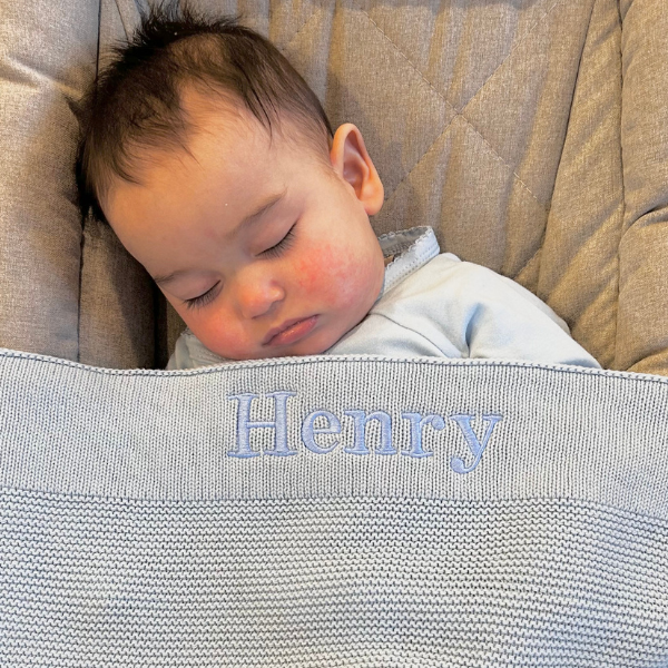 baby sleeping with personalised knitted baby blanket grey