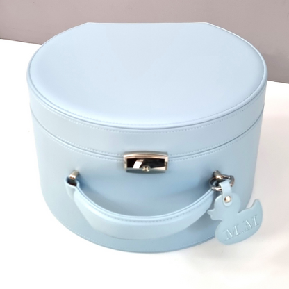 Light blue round baby keepsake box with a handle on a white surface