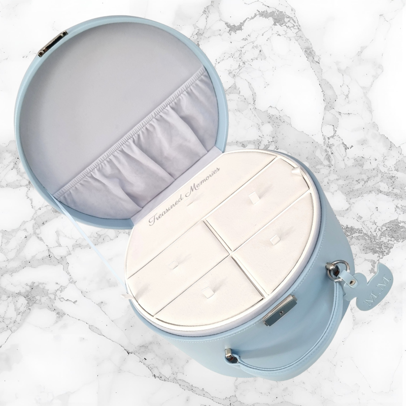 Light blue baby keepsake box with a white memorie insert tray on a marble surface