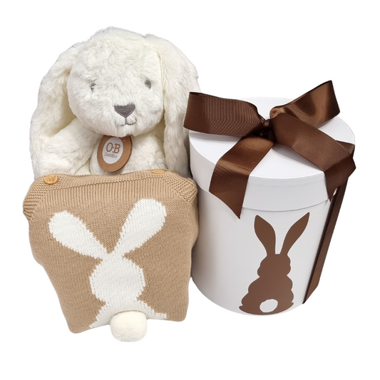 A baby gift hamper set including a neutral toned knitted bunny romper, a plush bunny toy, and a gift hat box with a bunny silhouette design.
