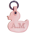 Pink duck-shaped keychain with 'AM' initials embroidered on a white background