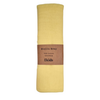 A yellow cotton muslin baby wrap with a label that reads 'Muslin Wrap 100% Cotton 120x120cm 4 kids'.