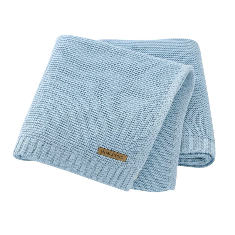 A folded knitted baby blanket in a light  blue color, displayed on a white back ground