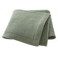 A folded beige knitted baby blanket with a solid line bordered edge, displayed on a white background