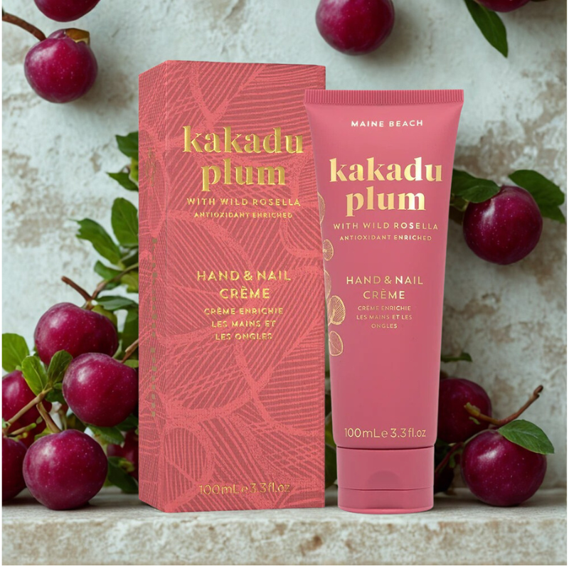 Kakadu Plum hand and nail crème packaging with product on a textured surface with fruits.