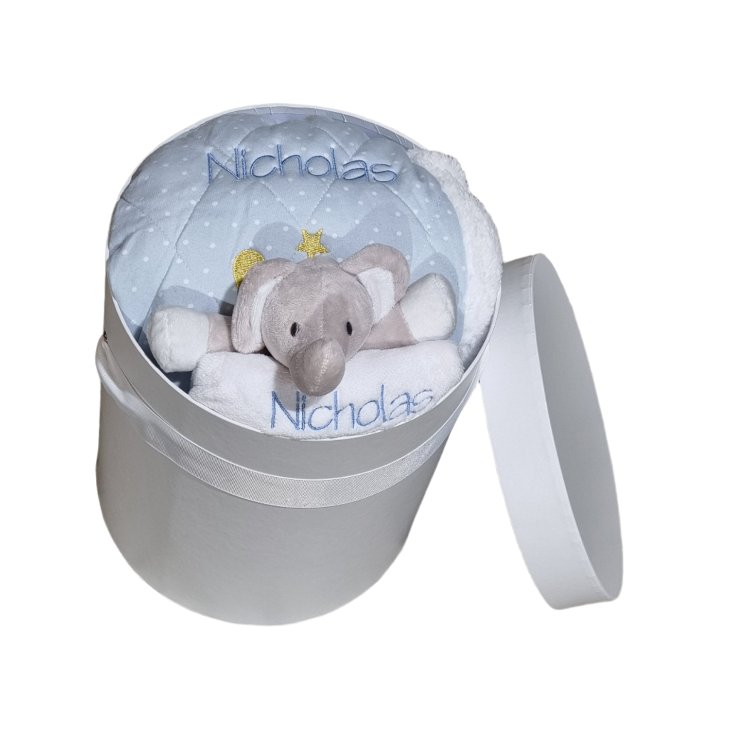 a blue baby gift hamper with a personalised embroidered name (Nicholas) on the blanket and towels, a stuffed elephant placed in the center popping out slightly.