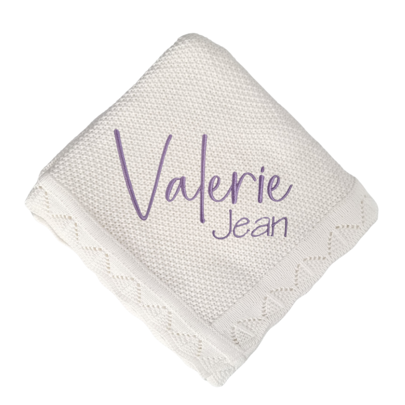 White knitted blanket personalised with 'Valerie Jean' embroidery in lilac on a white background