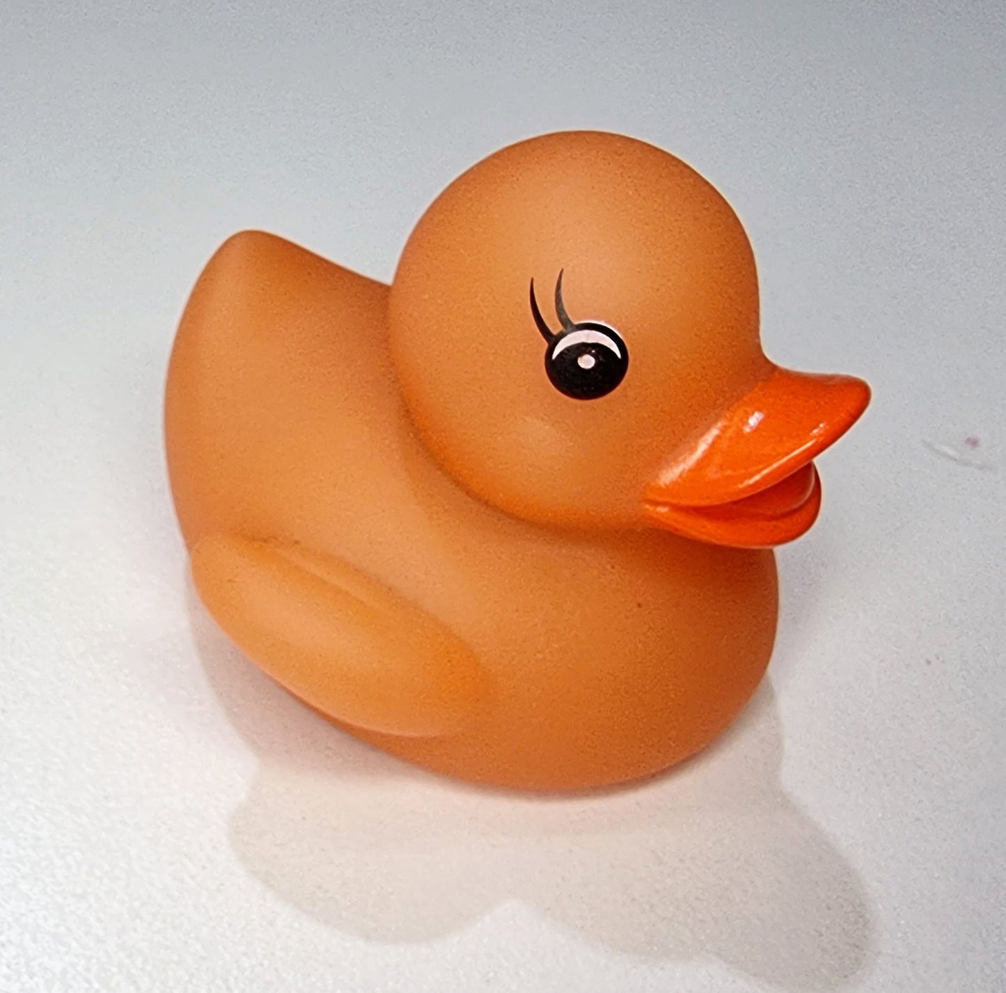 orange bath ducky changes colour in warm water . baby bath toy