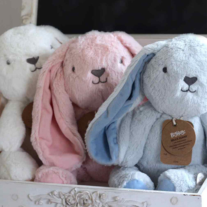 pink blue cream large bunny toys sitting in a row