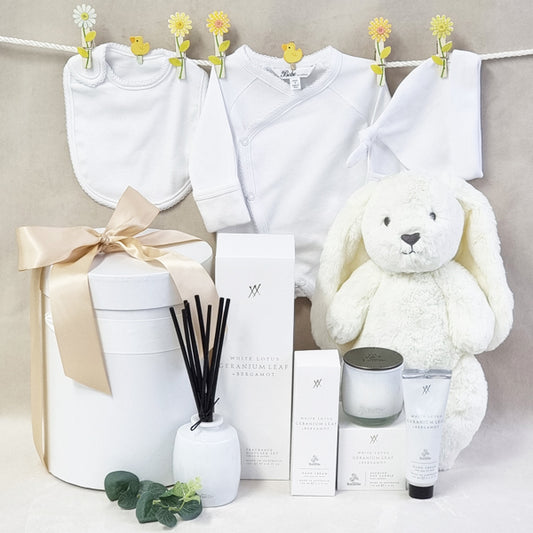 Mama and baby neutral white organic gift hamper with suit, beanie, bib, soy candle, room diffuser and hand cream.