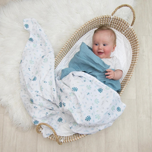 Baby wrapped in 2 piece organic muslin sage green banana leaf design baby swaddle.