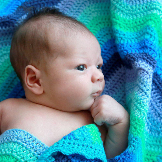 baby with multi colour blue crochet blanket