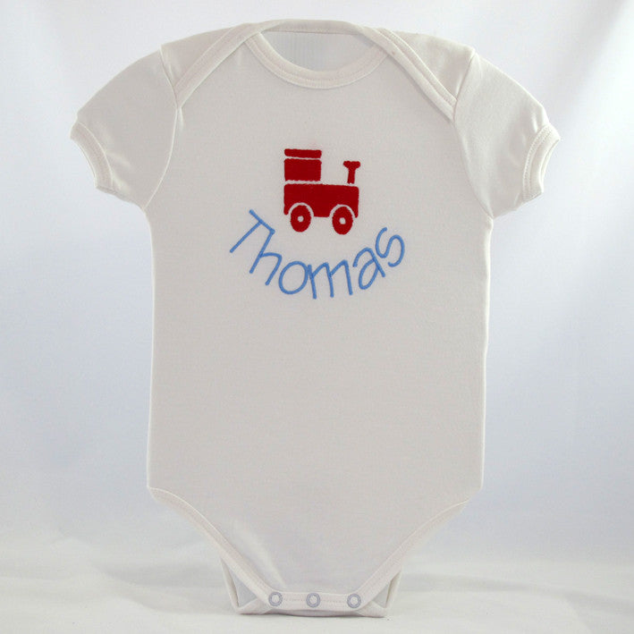 a personalised white baby body suit embroidered with a cute train design with baby's name underneath