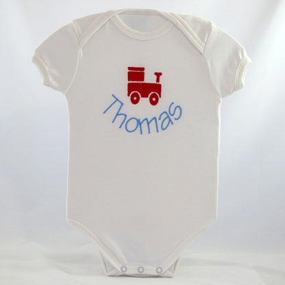 a personalised white baby body suit embroidered with a cute train design with baby's name underneath