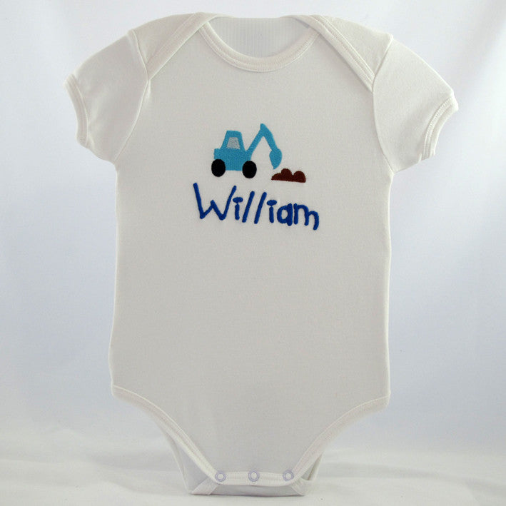 personalised baby baby body suit embroidered with a trucks and tractors motif along with the baby's name underneath