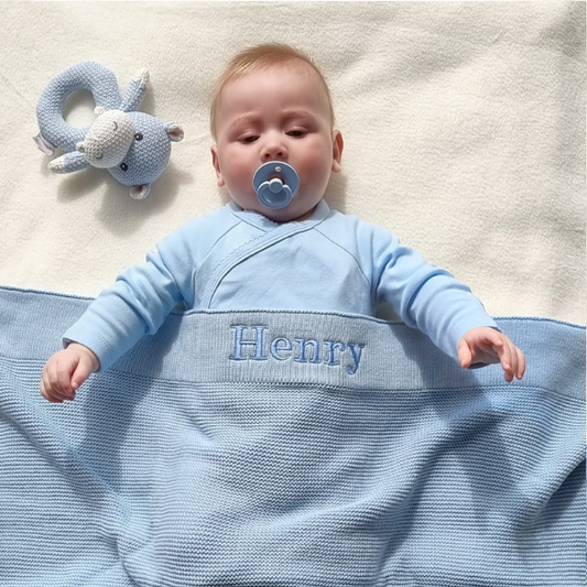 personalised knitted baby blanket in blue baby and hippo rattle