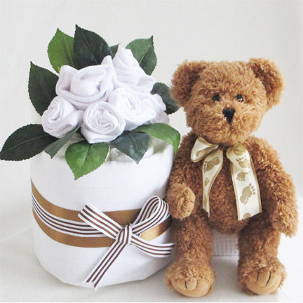 neutral baby nappy cake with tan teddy and white baby clothing